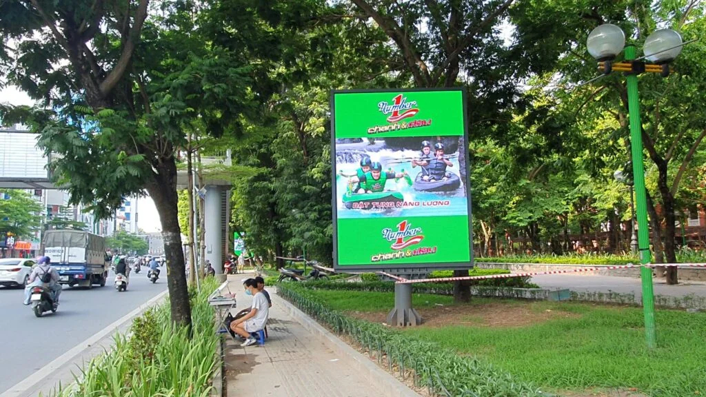 Minh họa LED đường phố và đường dạo ven hồ: Màn hình dọc tại dải cây xanh cạnh tuyến phố